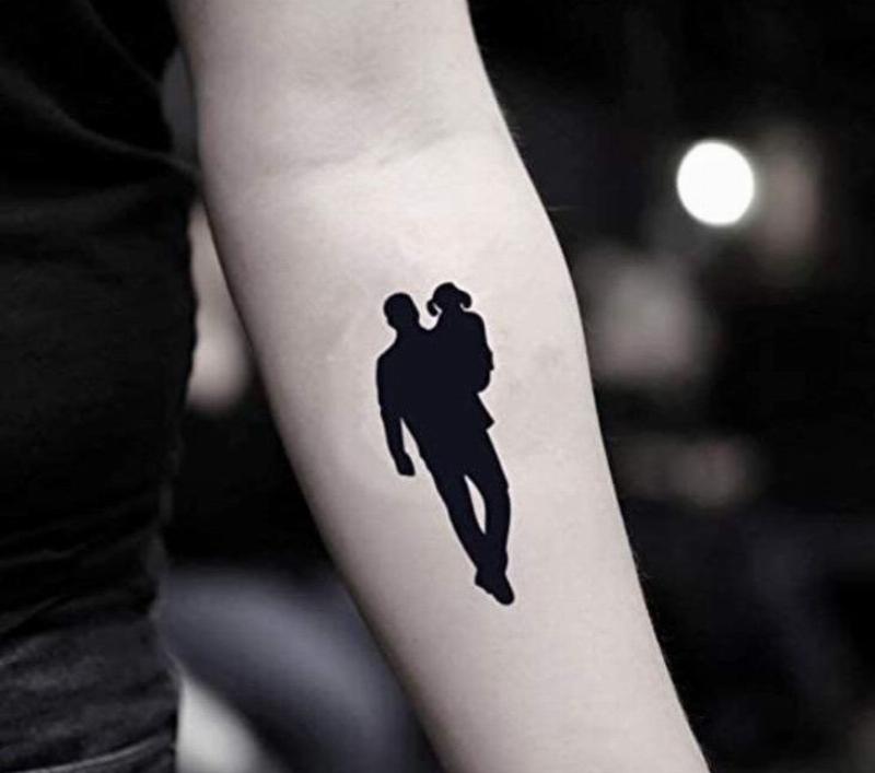 Hình xăm mẹ con đơn giản với nét silhouette mẹ và con gái nắm tay, tinh tế và ý nghĩa